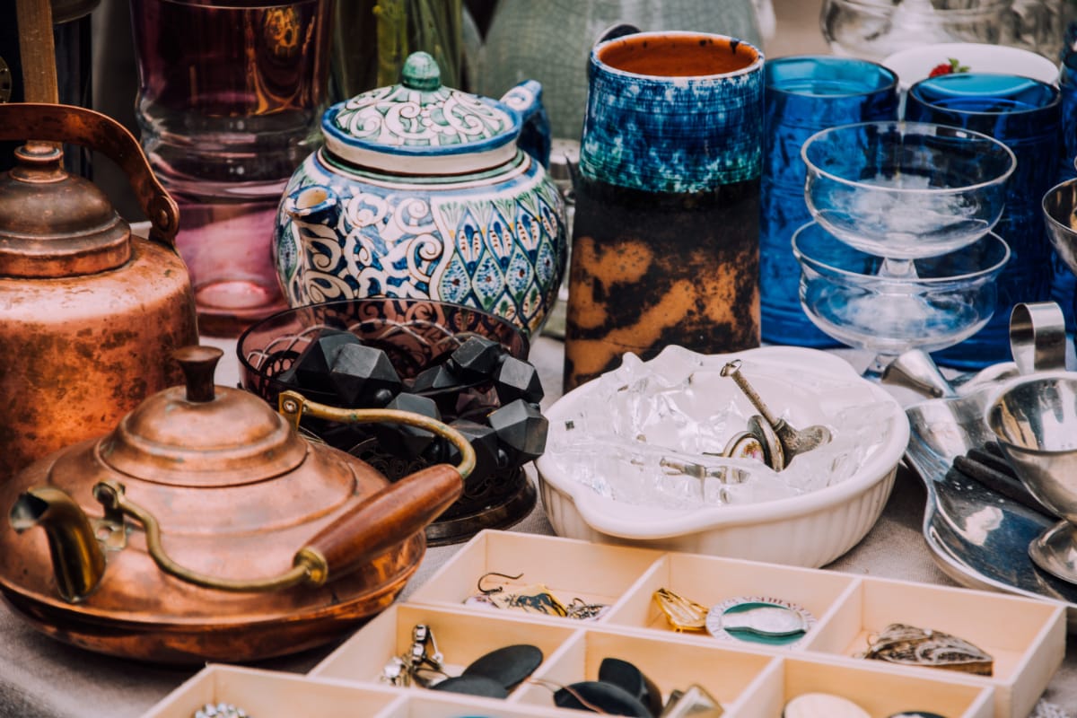 vintage teapots, glasses, and jewelry on a table