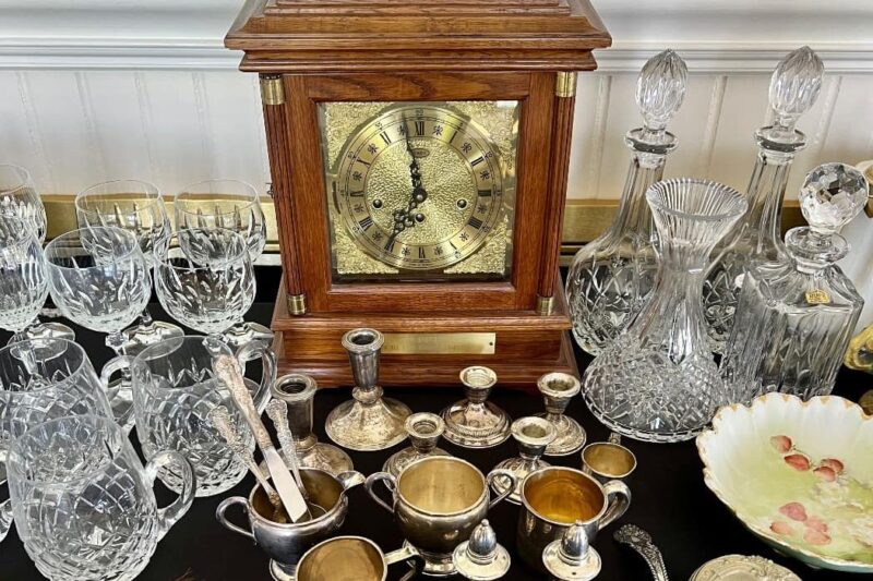 display of candle holders, glass decanters, fine china, and a beautiful table clock