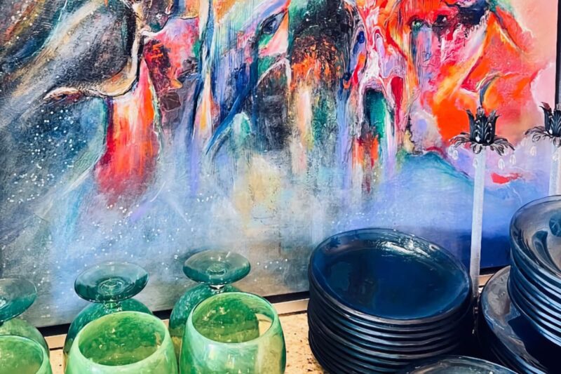A painting by artists Yiannis Karimalis behind some glassware